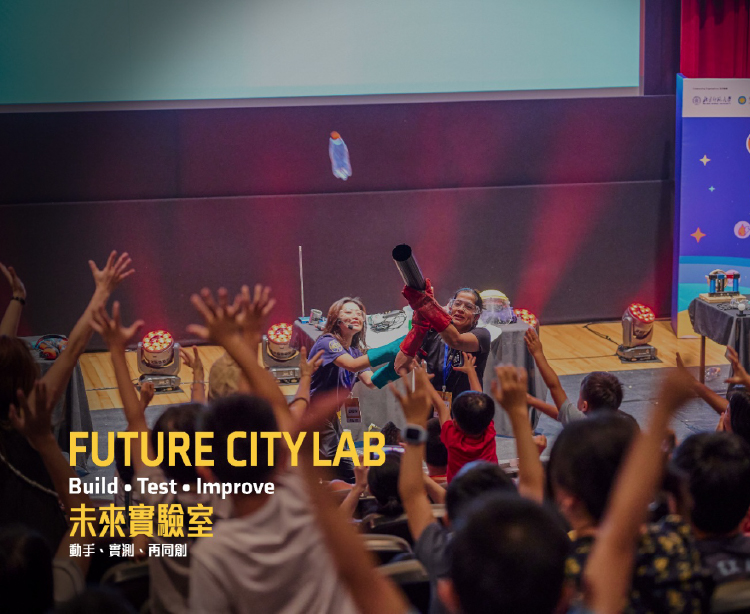Children raise their hands as the facilitator demonstrates a science experiment with a launcher.