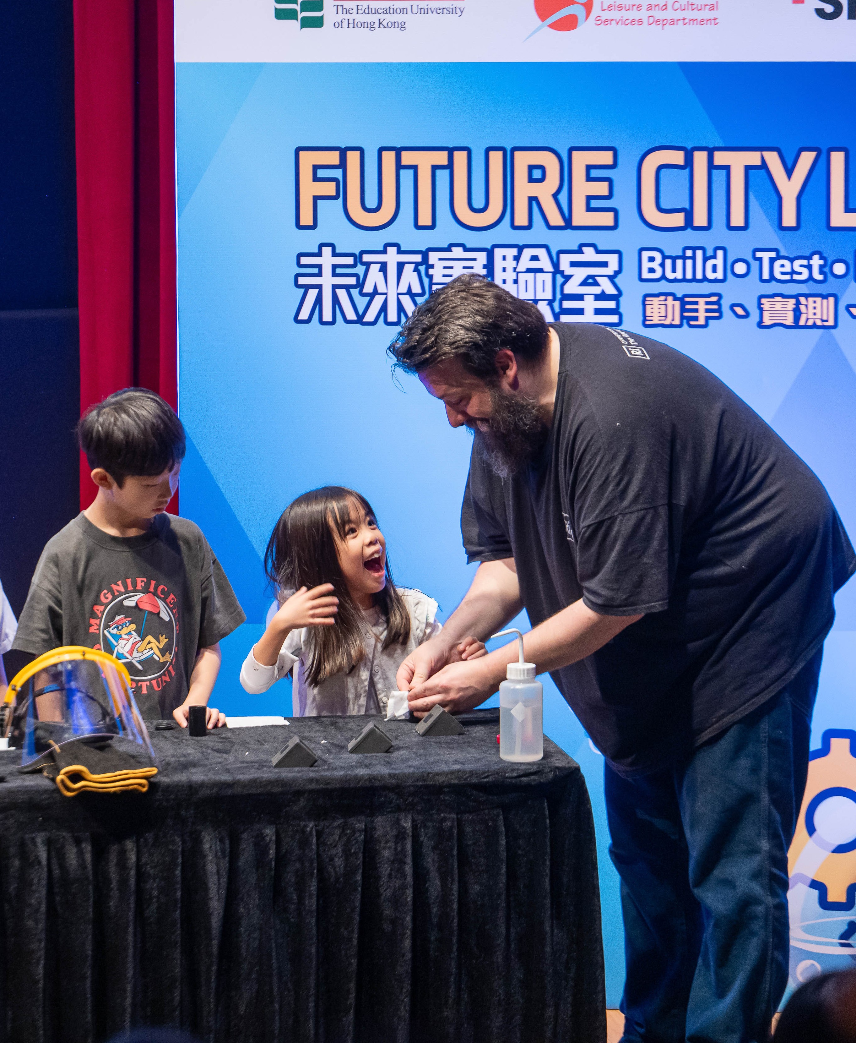 A young student smiles with excitement while participating in a hands-on robotics activity at the JC CoolScience Carnival 2026.